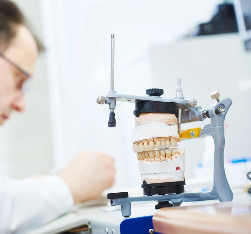 A man working with dental equipment in front of him.