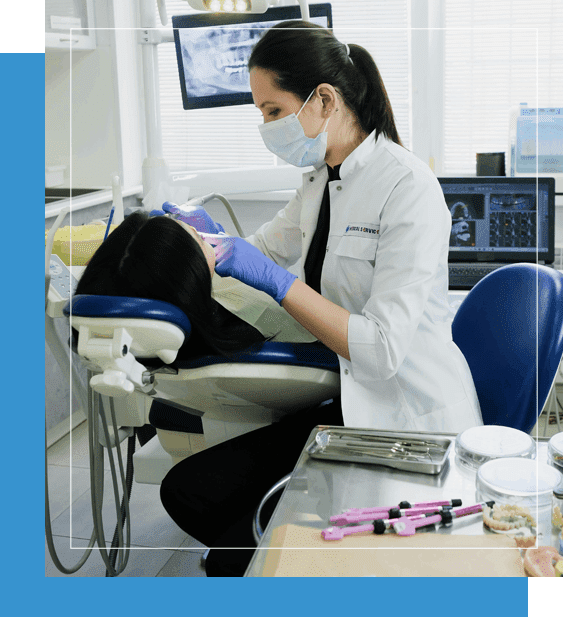 A woman in white lab coat and blue gloves working on something.