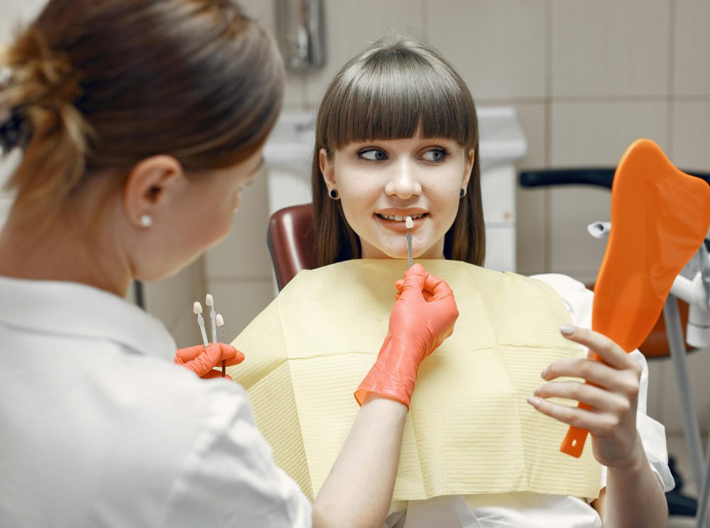 A woman is getting her teeth checked by an orthodontist.