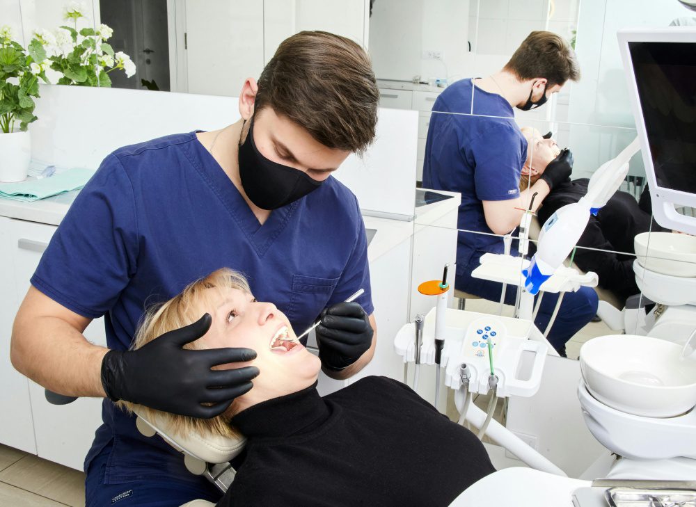 A dentist is examining the teeth of a patient.